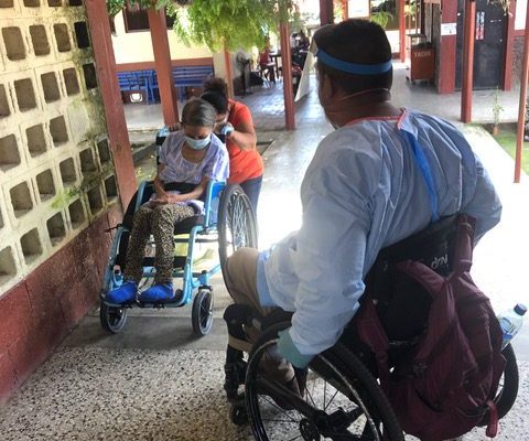 Mynor, Wheelchair Technician, teaches a family member to use the new chair